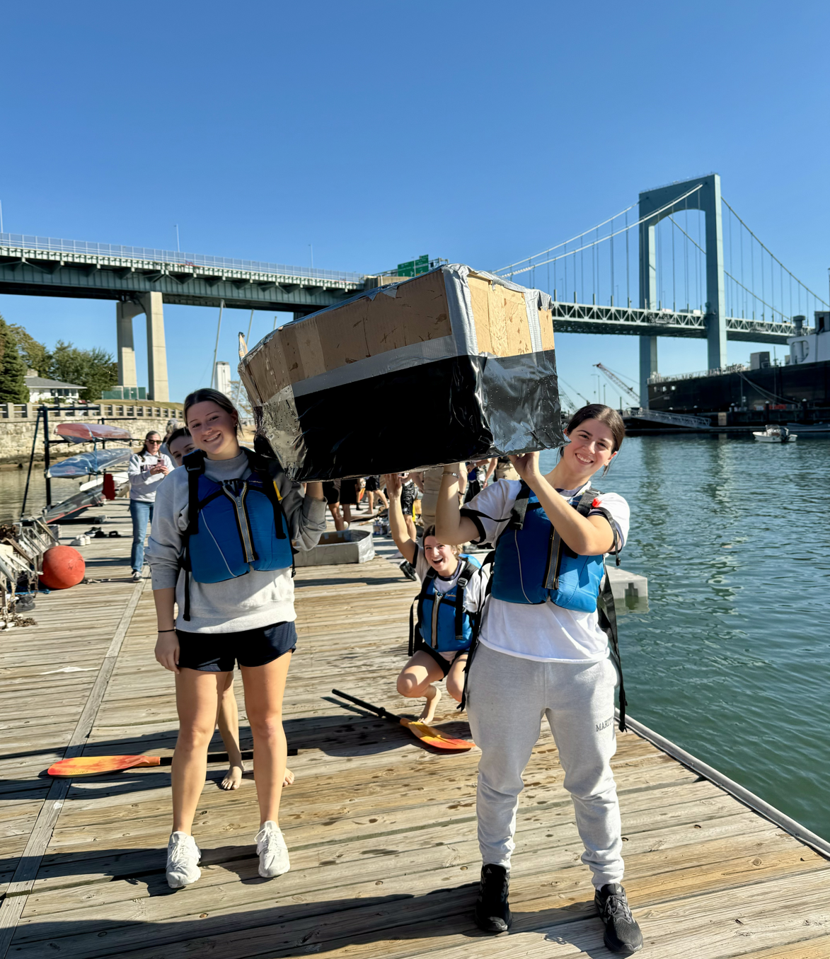 Students carrying handmade boat